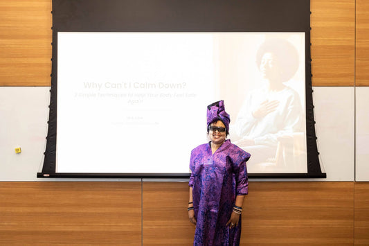 Idi E. Utuk wearing purple and a matching headwrap in front of the presentation screen at Crescent Foundation’s E.A.R.T.H. Summit.